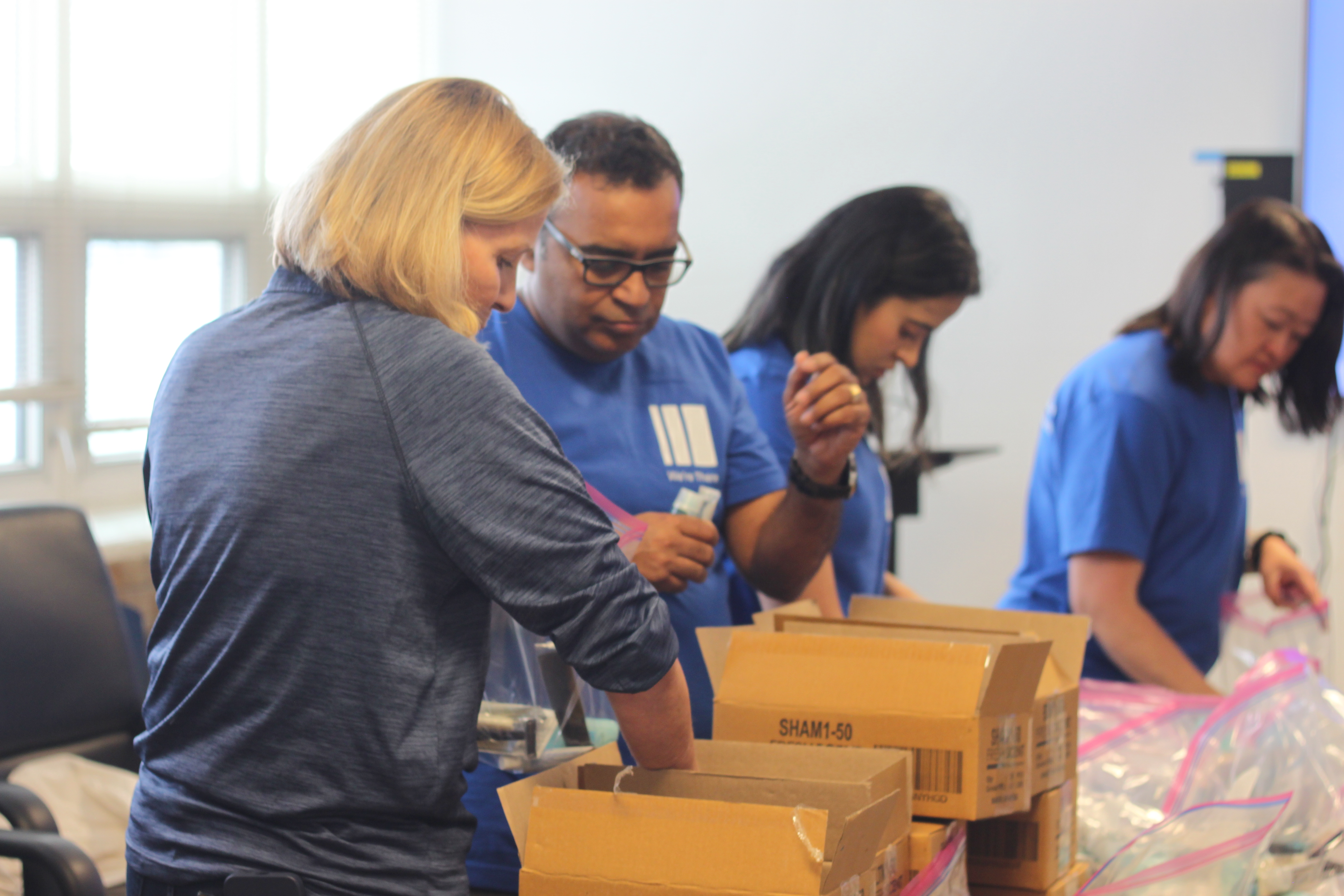 Volunteers pack boxes of supplies